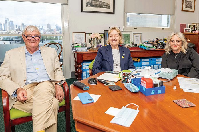 Three people sitting around a desk