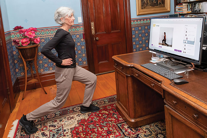 Woman at home doing exercises in front of a computer