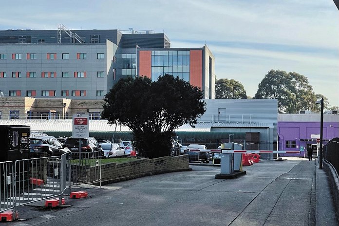 A view of RPA's western campus, showing on-grade parking with the Professor Marie Bashir Centre in the background.