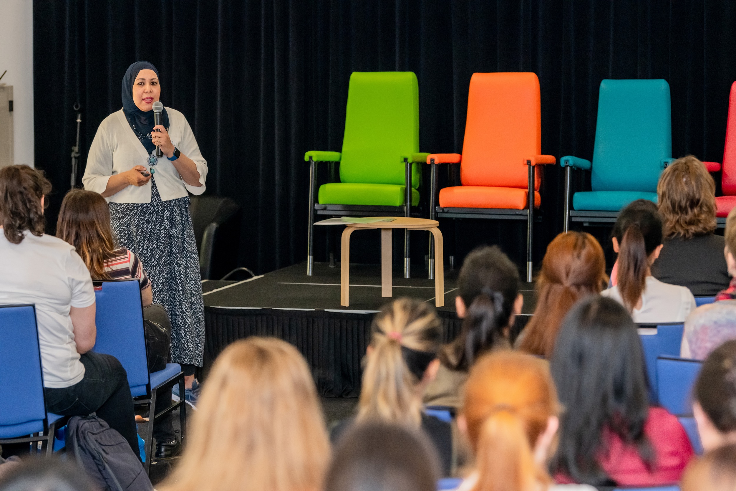 Facilitator speaking to an auditorium of new employees.