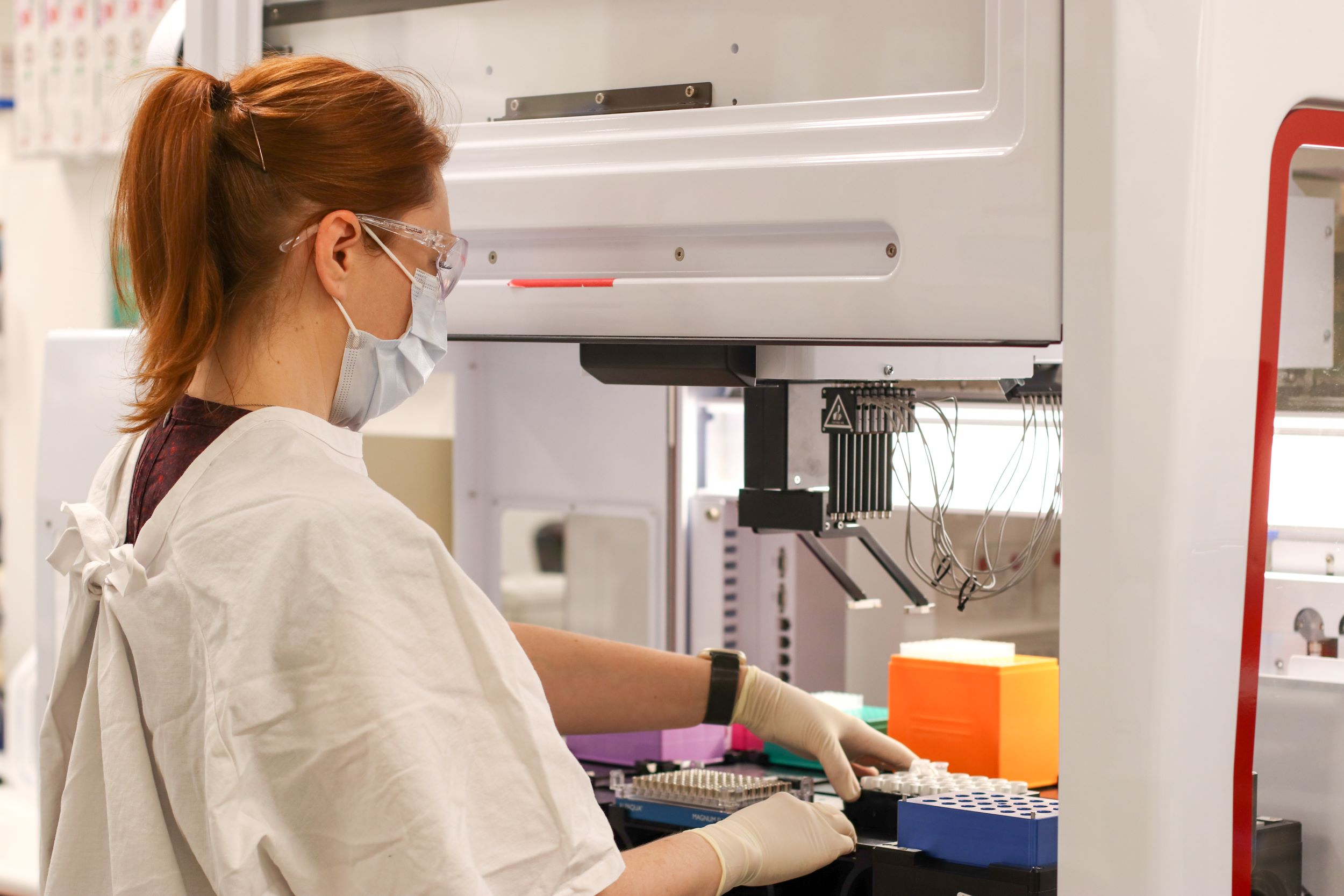 Scientist loading samples into liquid handling workstation