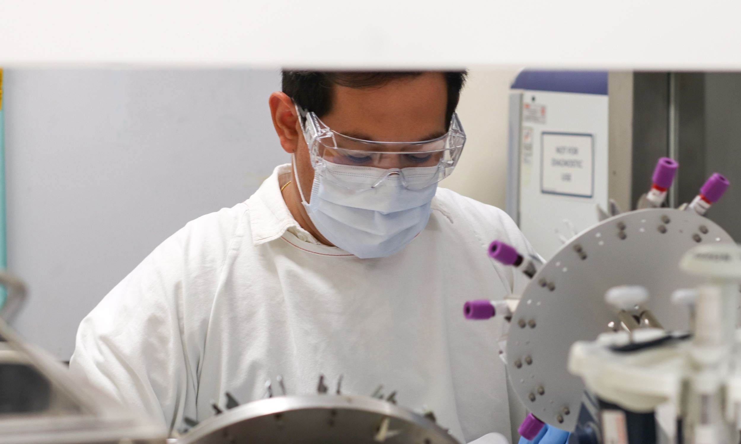 Scientist in a lab coat; performing tests in a lab