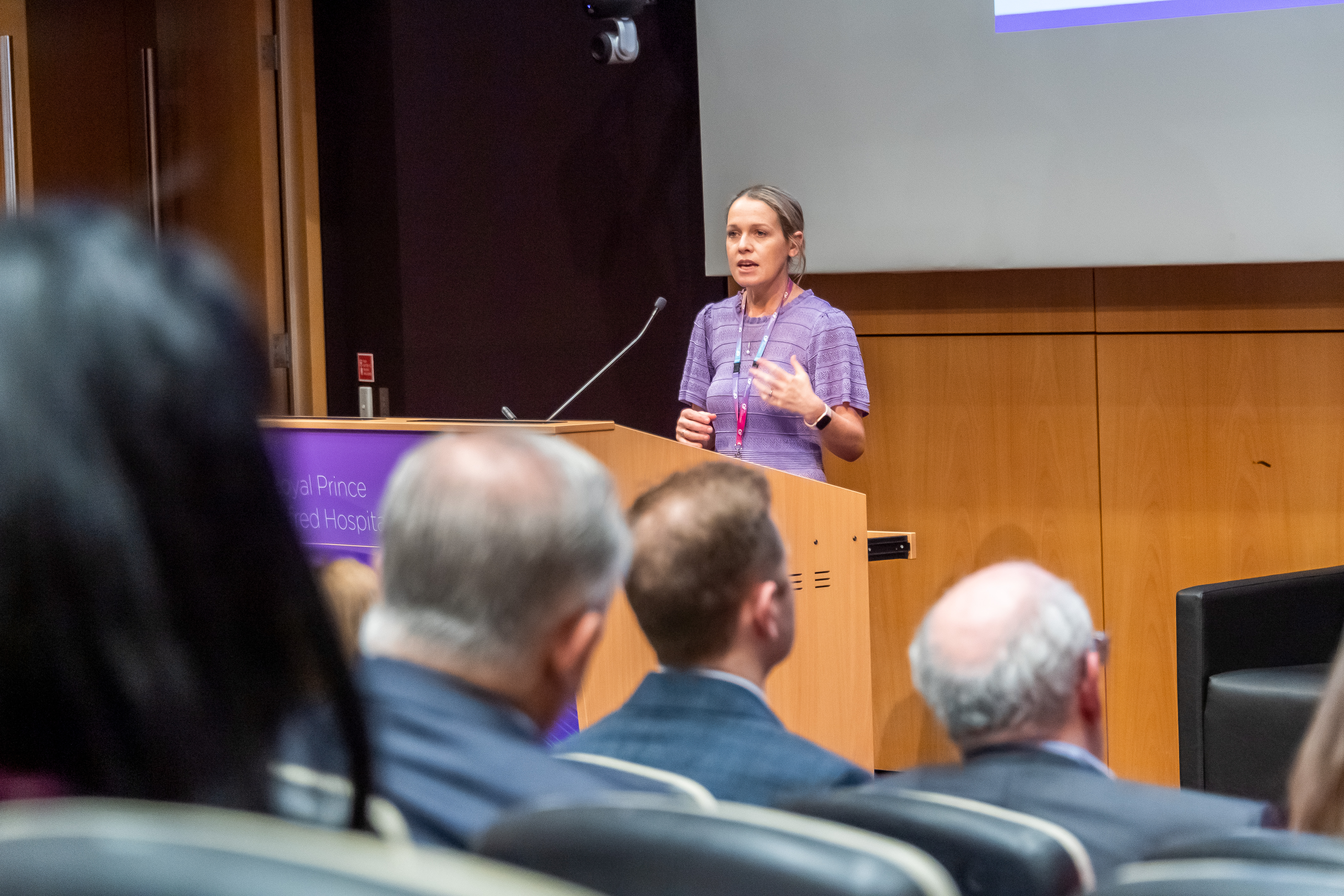 Woman speaking at a podium on a stage.