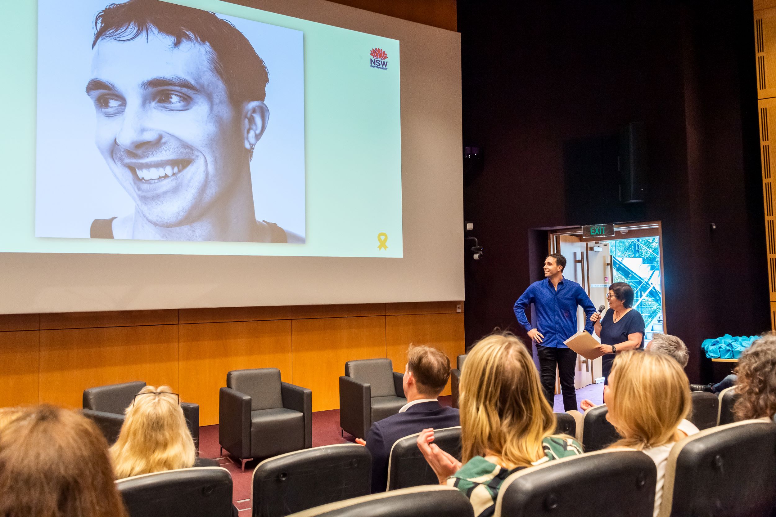 Woman interviewing man in front of presentation screen