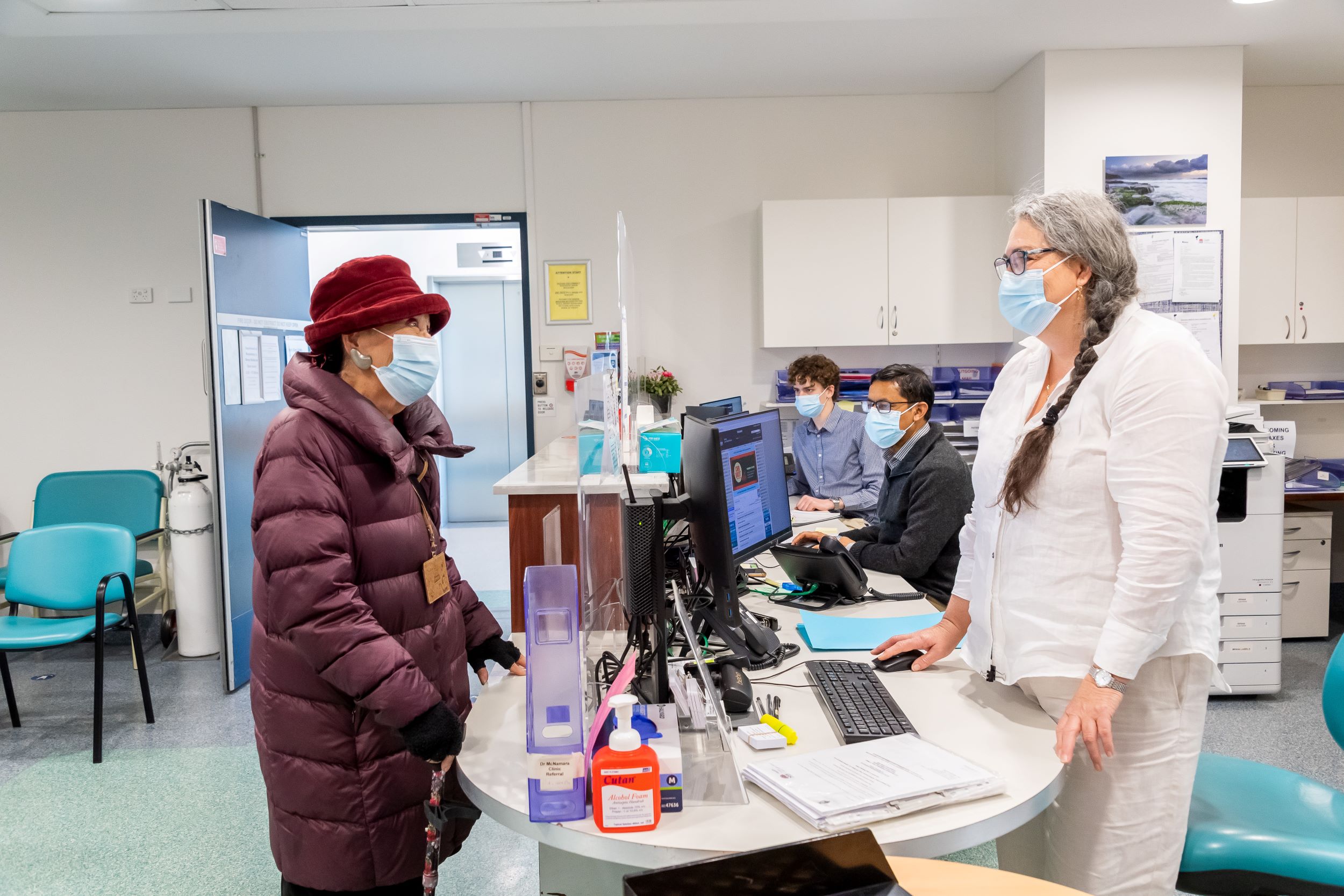 Patient talking to another woman at hospital reception area