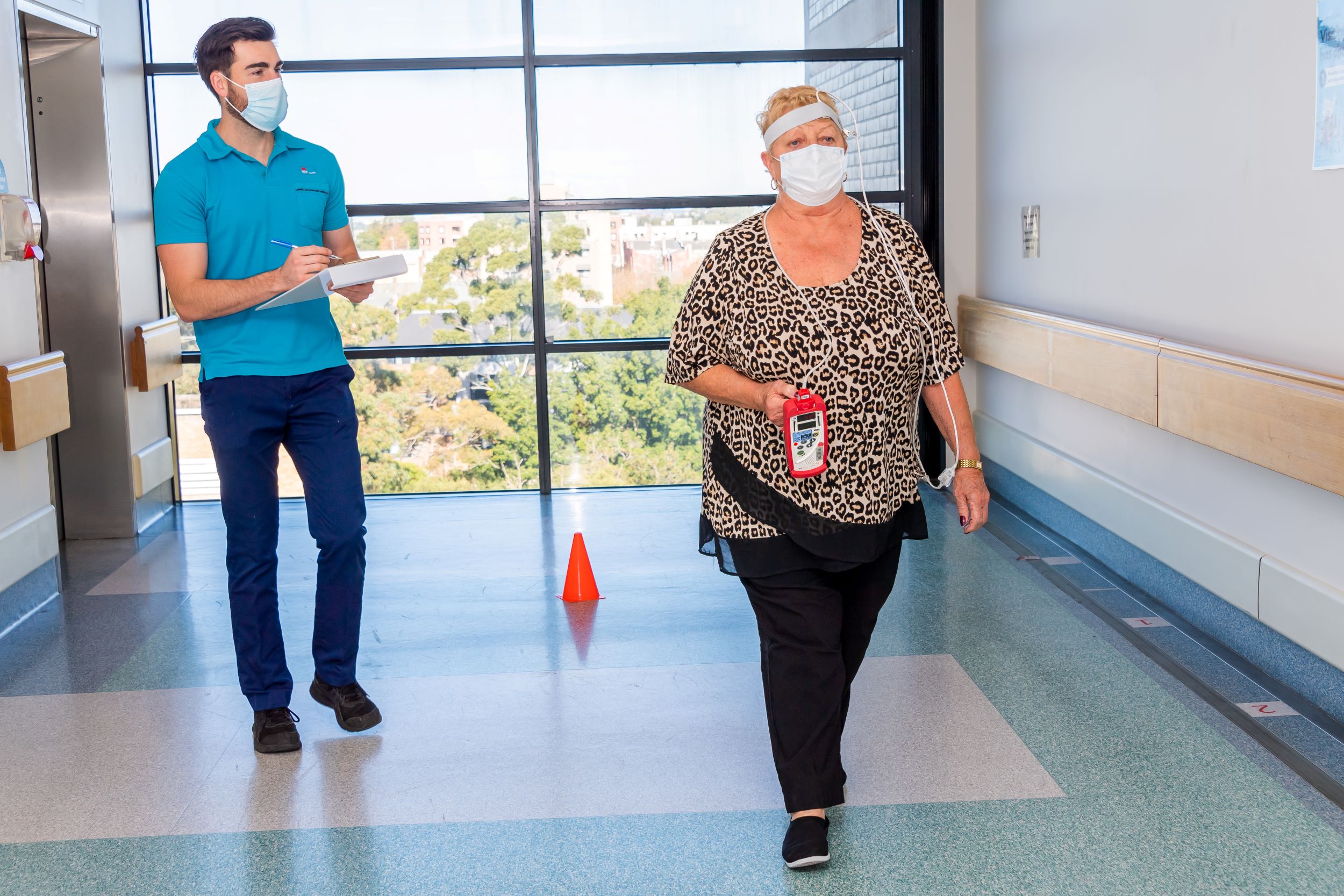 Man in clinical uniform watching a woman walk 