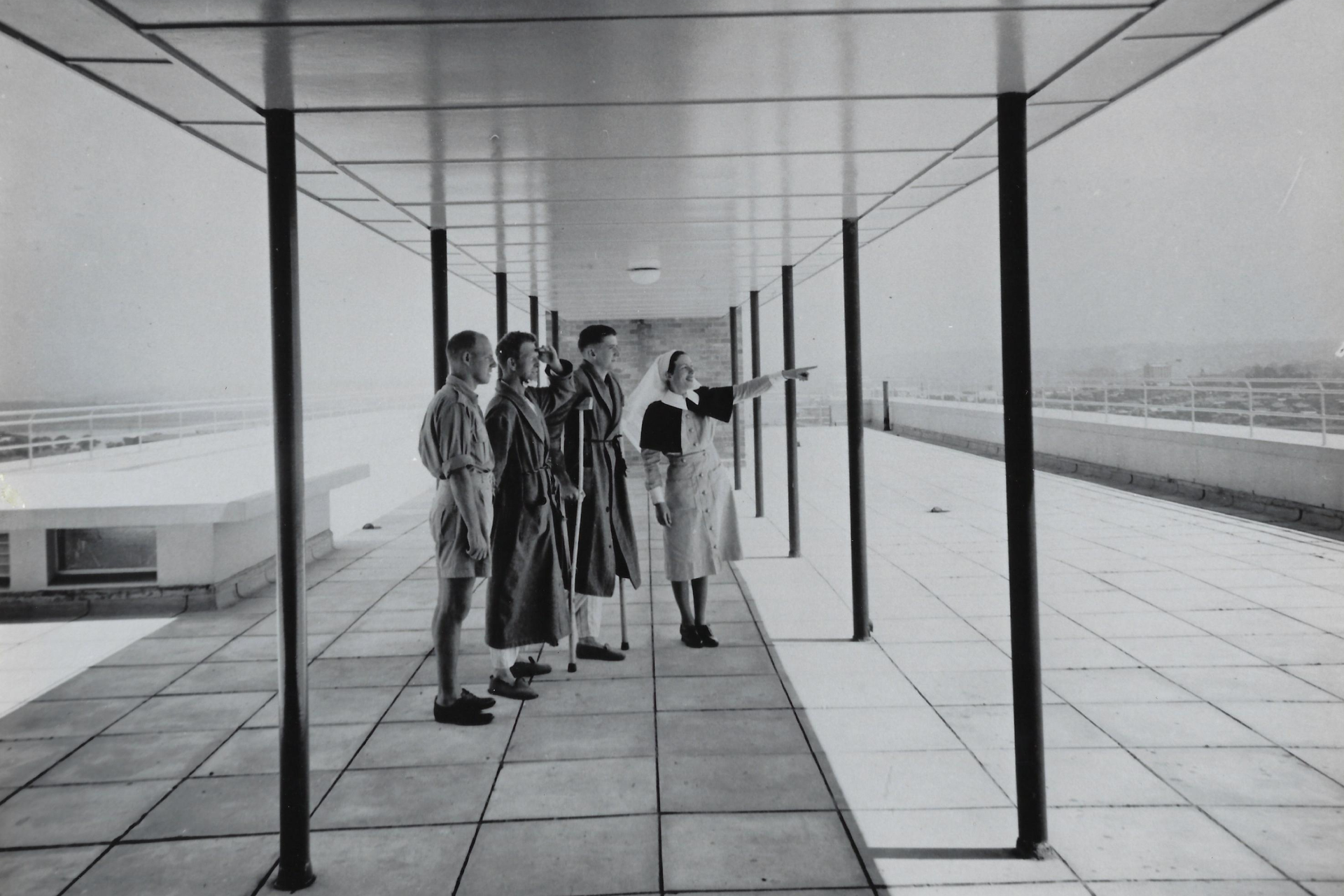 black and white photo people standing on building rooftop