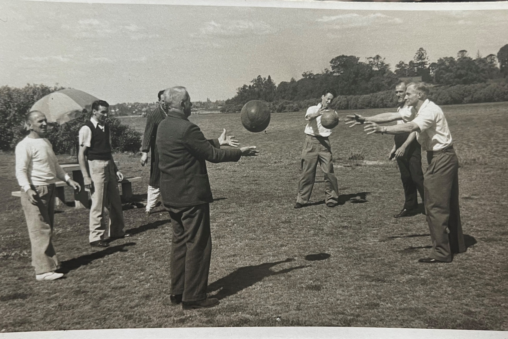black and white photo people playing a ball game outside
