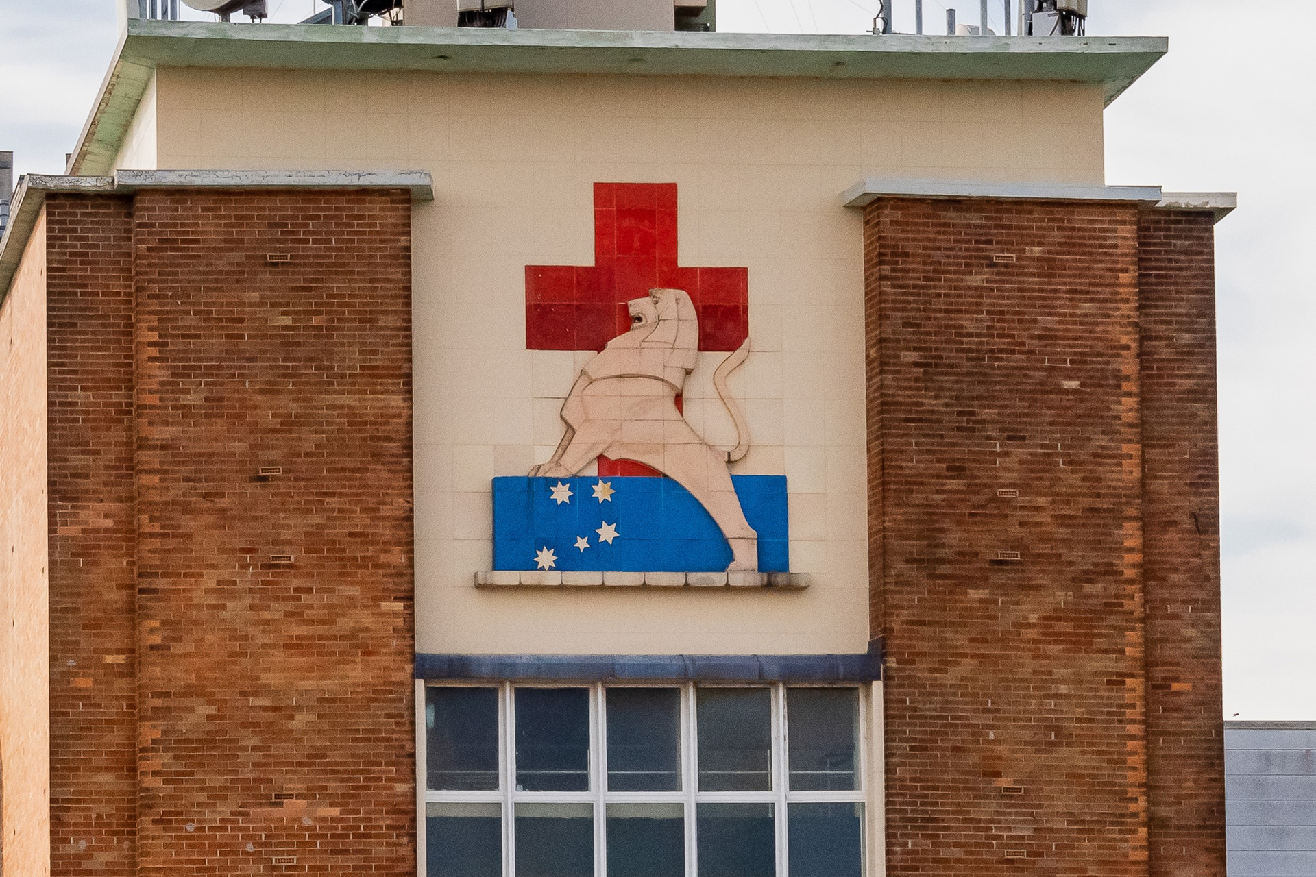 Photo of a Lion red cross crest on top of a building