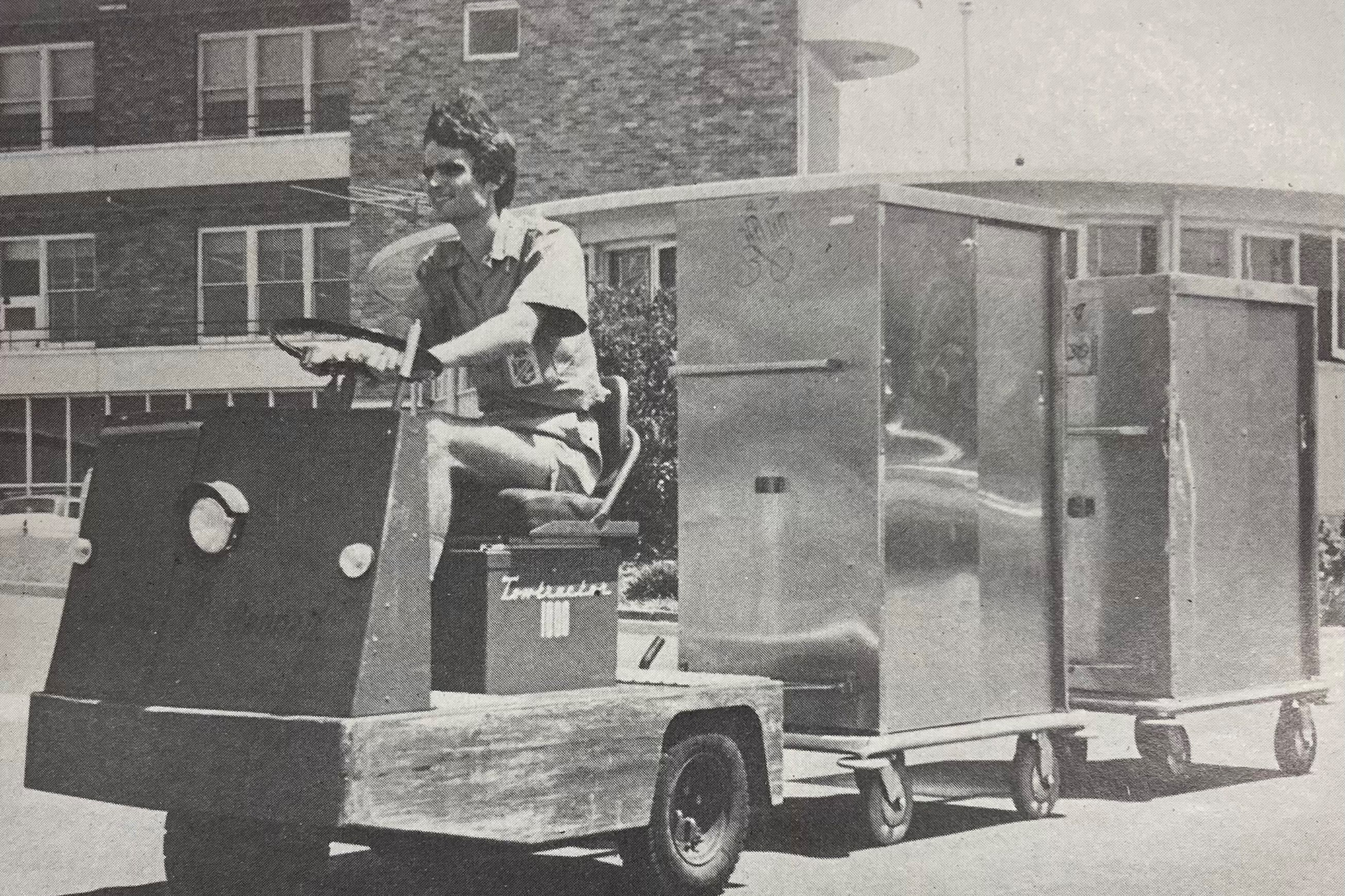 black and white photo of a person driving a cart vehicle