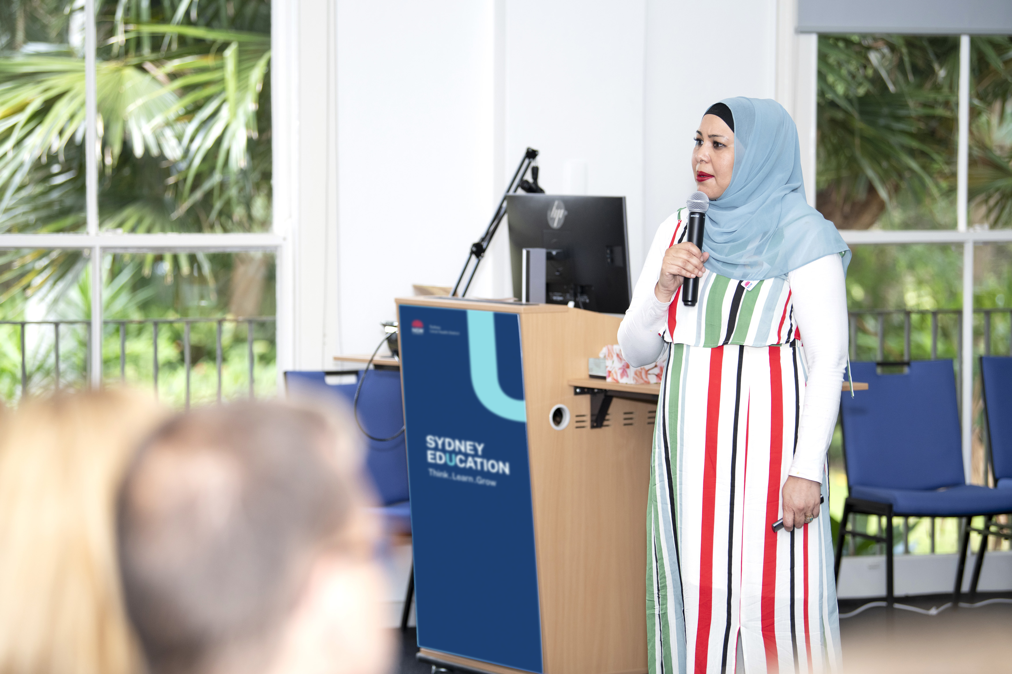 A woman holding a microphone speaking in a room