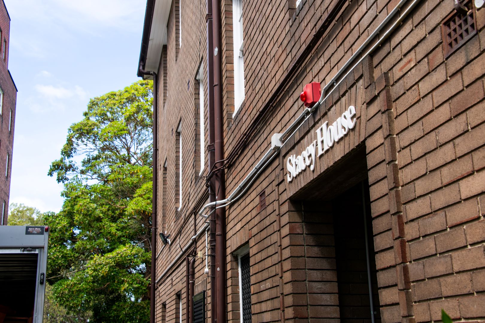 An external photo of a building with a Stacey House sign at the door