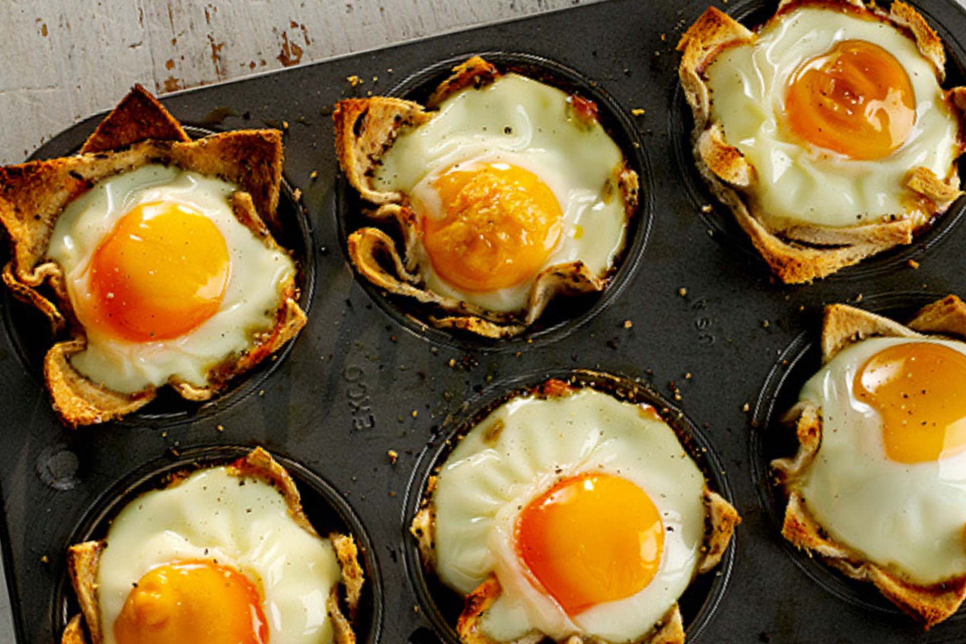 Baked bean and egg bread cups served in black baking tray