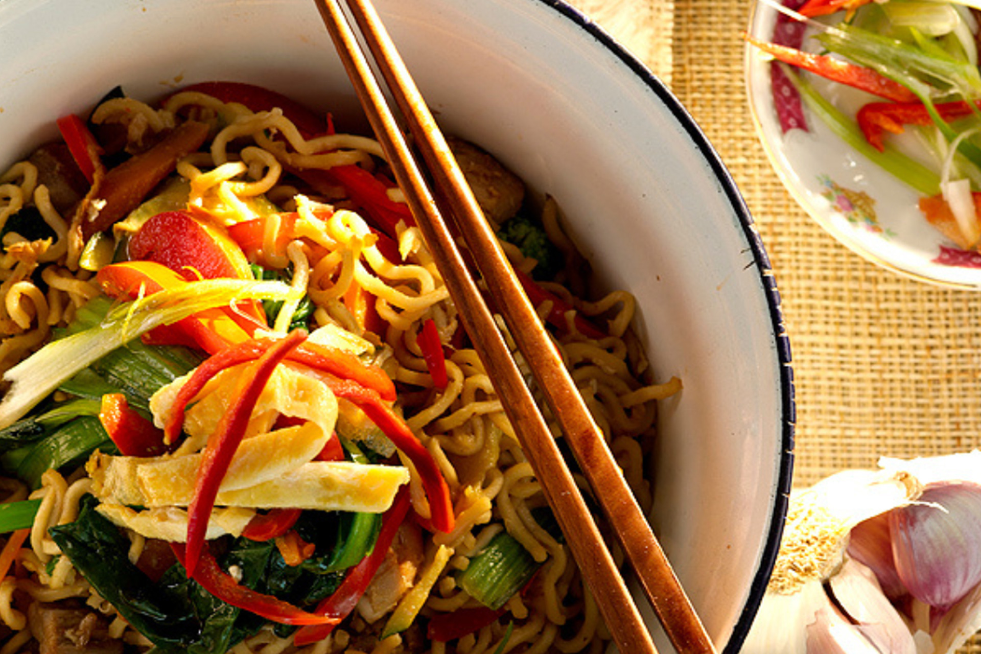 Homemade mi goreng served in a bowl with chop sticks