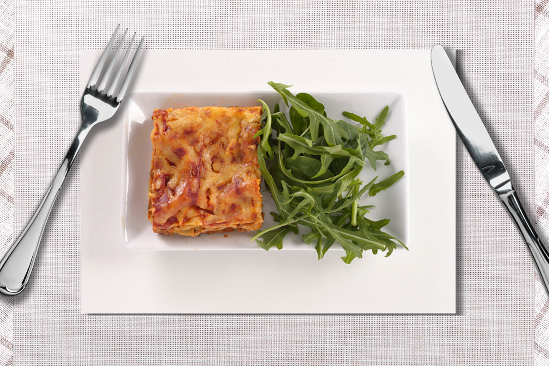 Lazy lasagne served on white plate with knife and fork