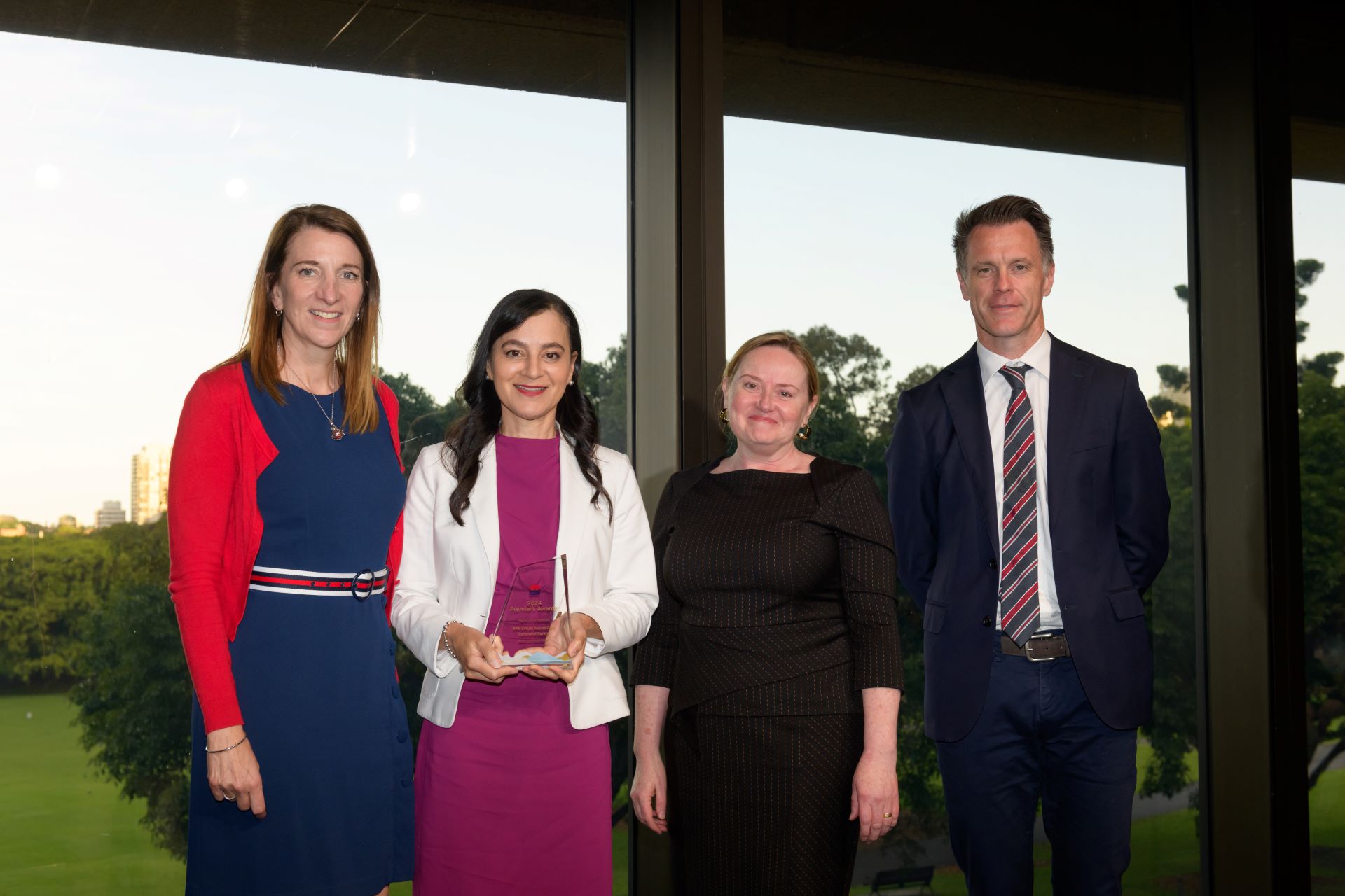 Four people standing together with an award