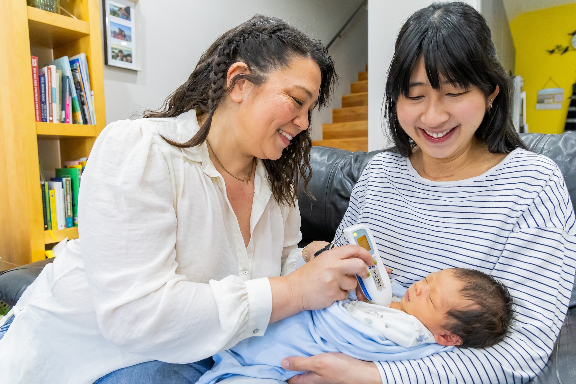 A midwife assists a woman to with her newborn baby