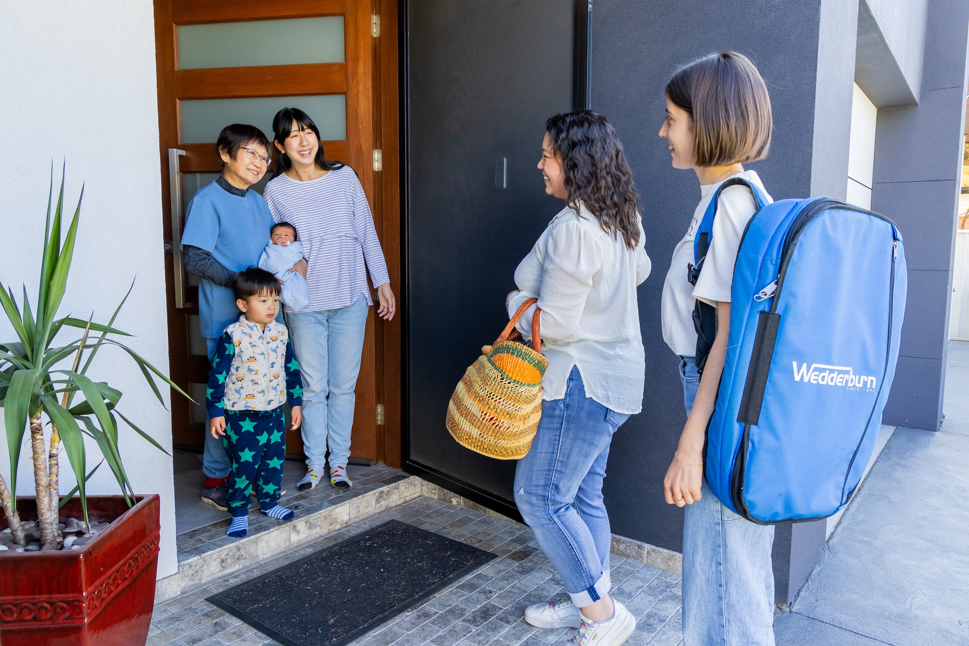 Two midwives at a patient's front door during a home visit