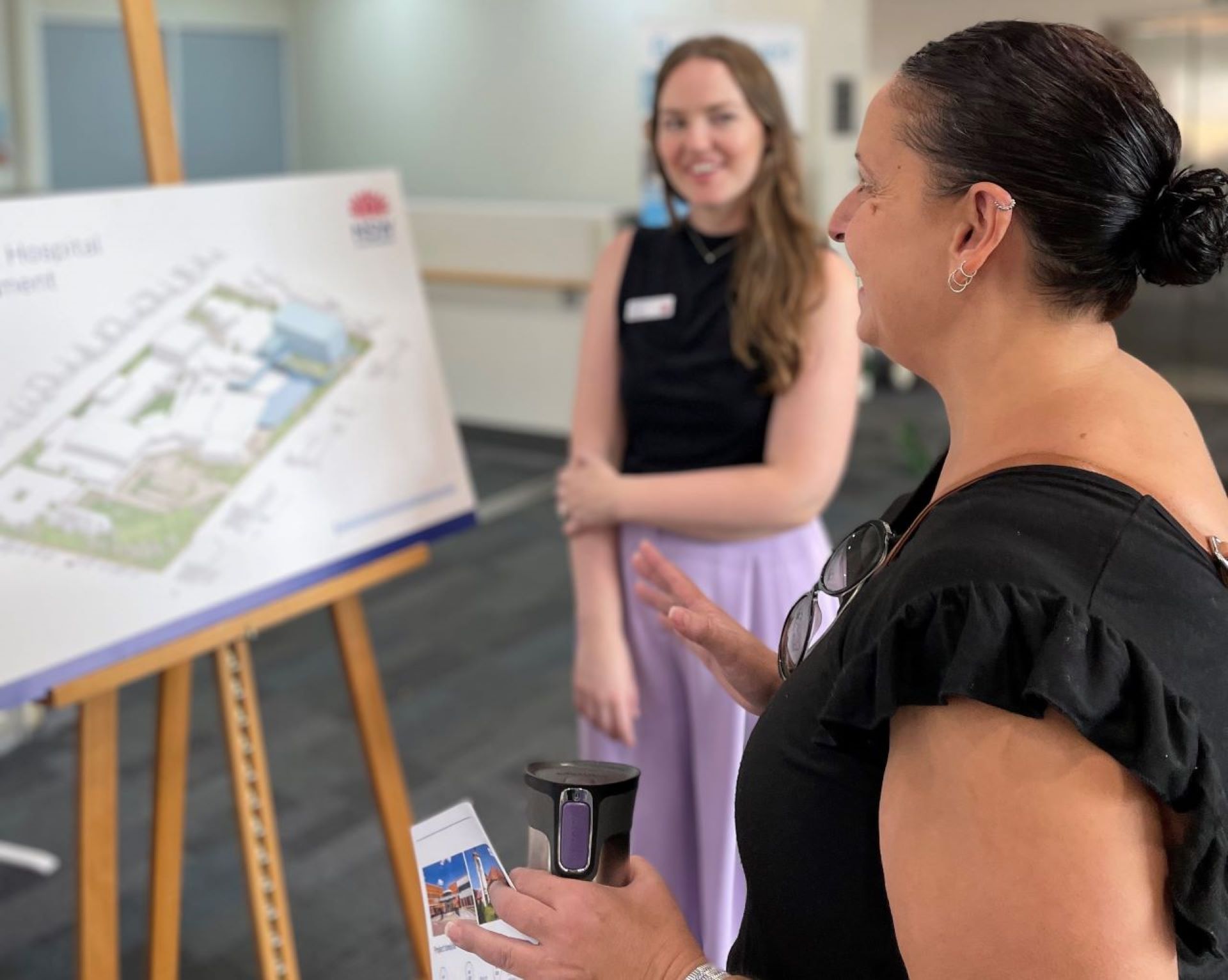 Two women talking about architectural plans