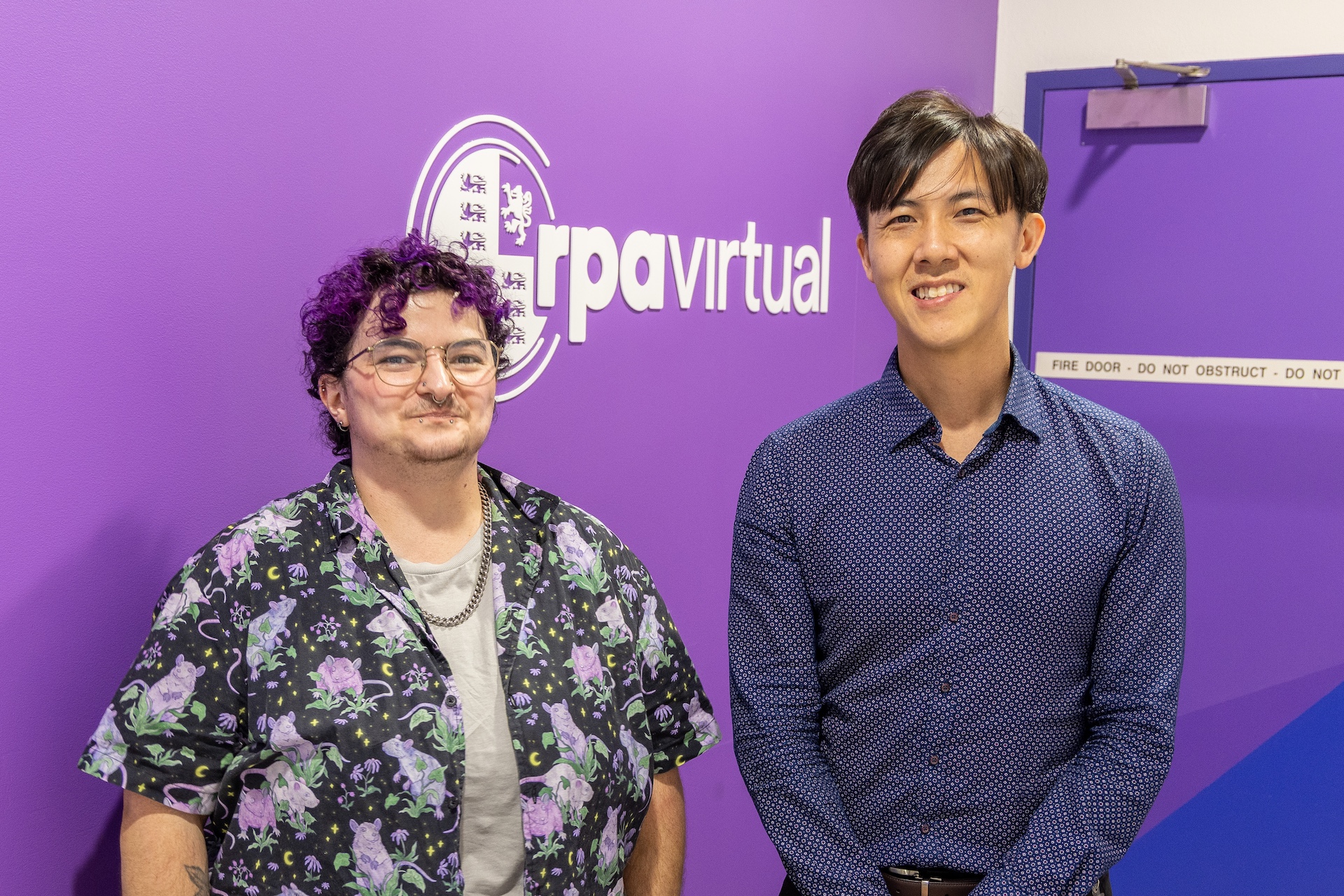 Photo of Alexa and Michael in front of RPA Virtual sign
