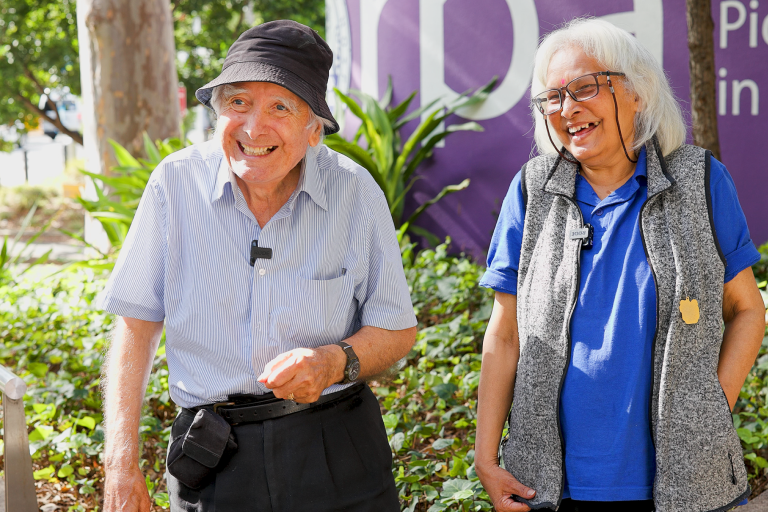 Paul and May Davio stand in front of a sign for RPA Hospital and smile.