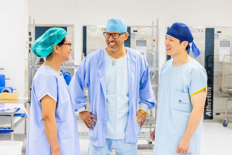 Three staff members in light blue scrubs