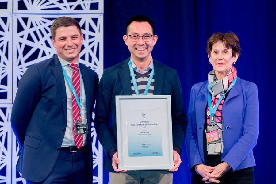 An award recipient posing for a photo with two executives.