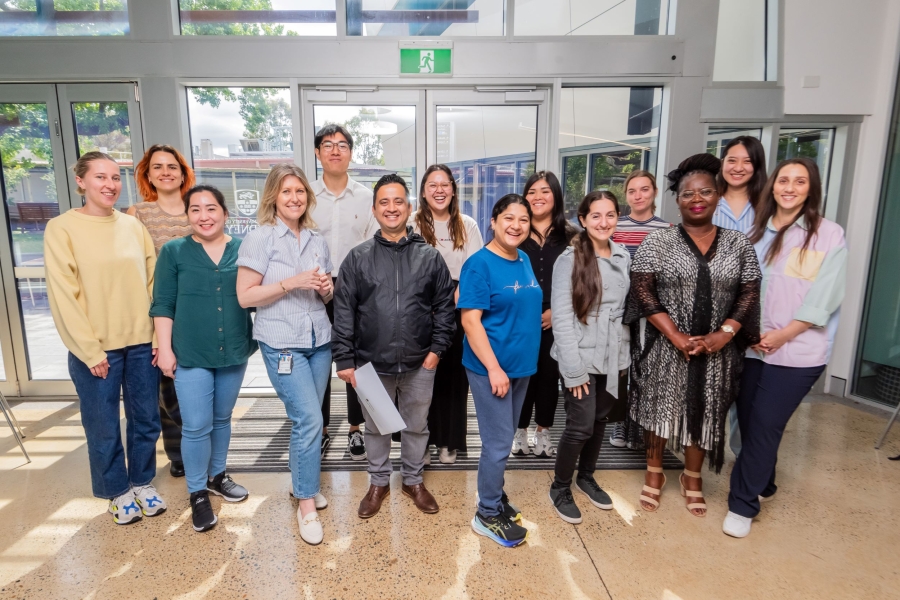 A group of mental health nursing graduates stand together in a group, smiling.
