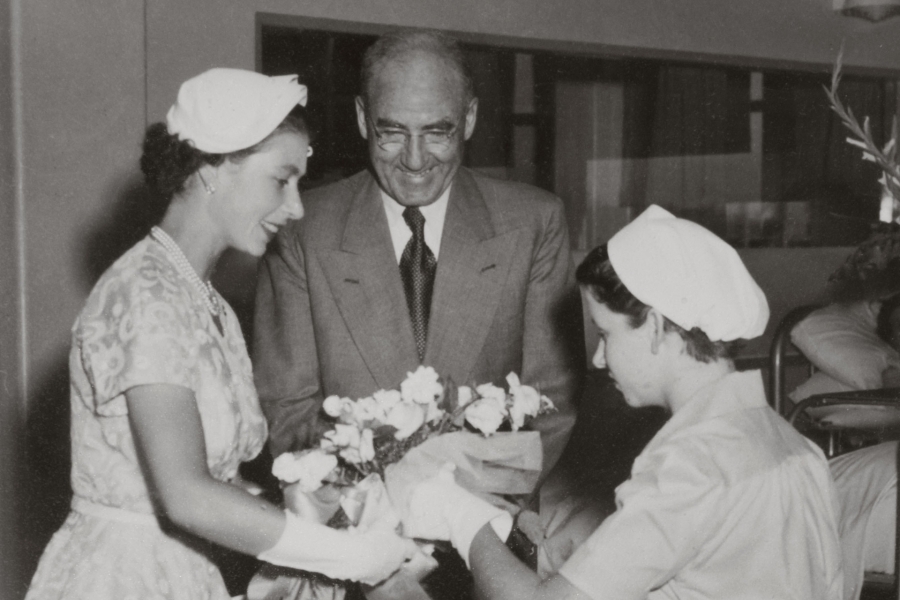 black and white photo of a woman and a man handing a woman in uniform a gift