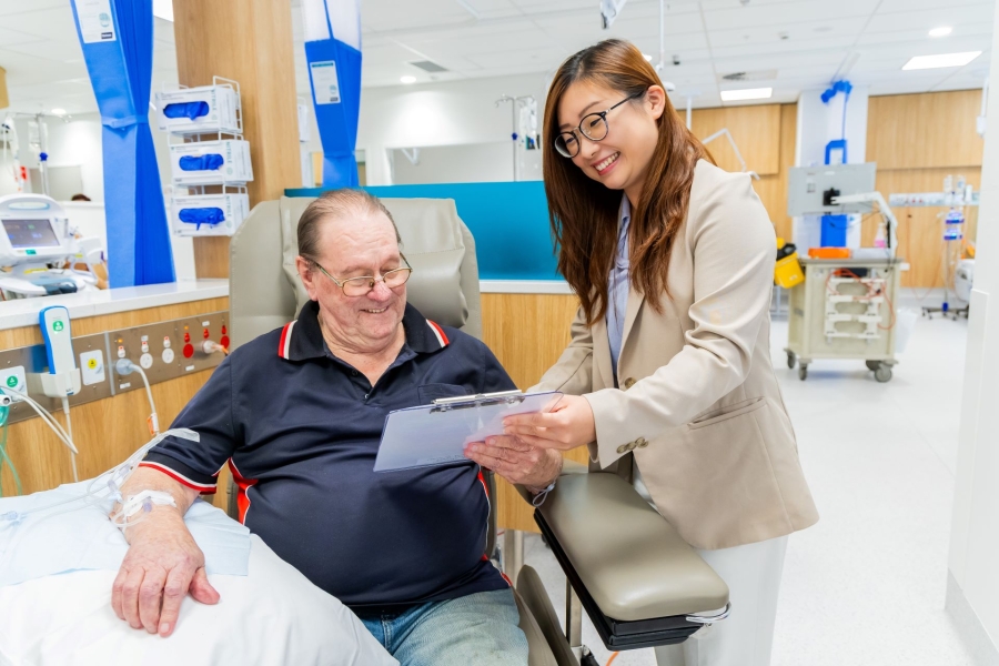 A person showing a patient some paperwork 