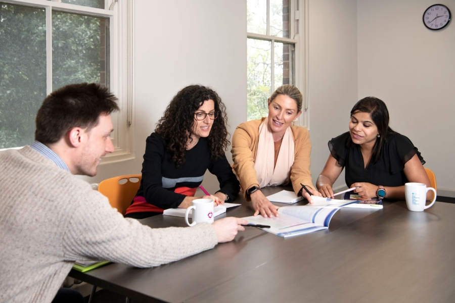 Four people sitting at a table conferring