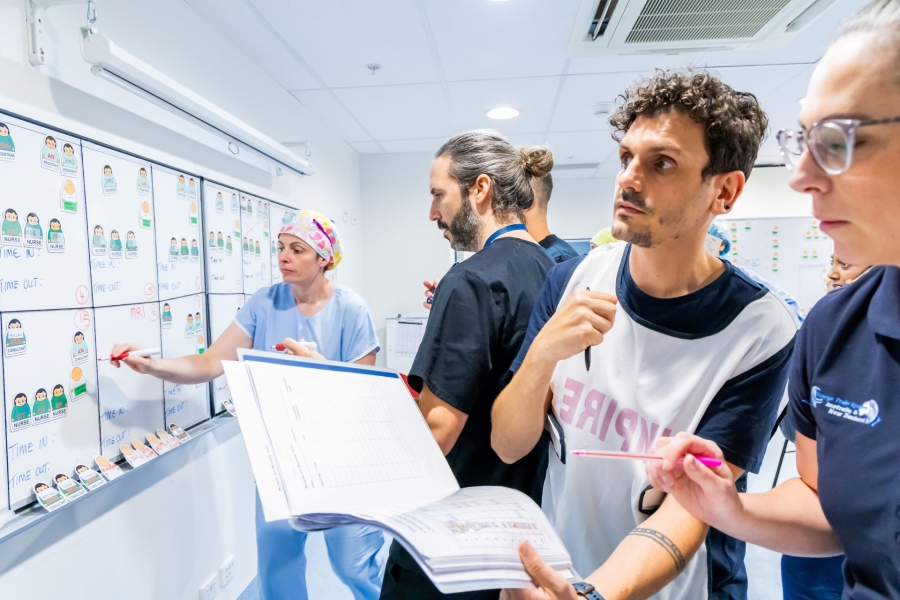Medical staff examine whiteboard with patient details